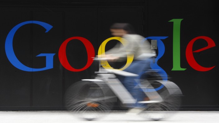 Fahrradfahrer fährt am Google-Logo vorbei