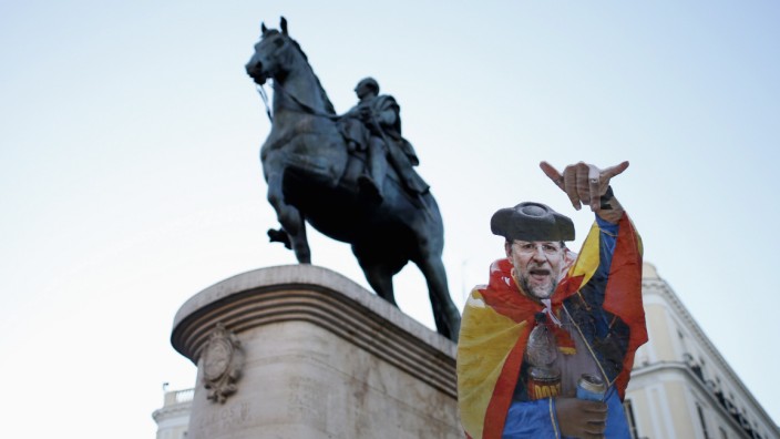 A man holds up cutout during a protest at Madrid's landmark Puerta del Sol