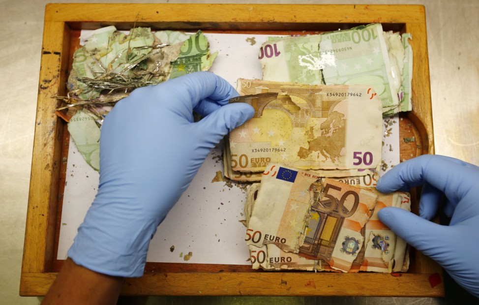 Forensic scientist inspects flood damaged euro banknotes at money analyzing laboratory of Germany's Federal Reserve bank in Mainz