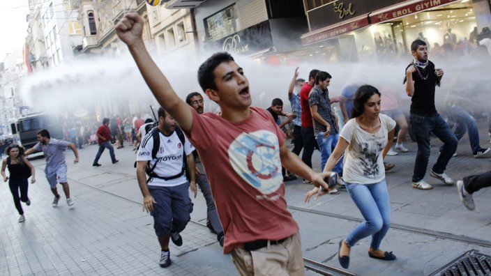 Anti-government protesters run from water cannons fired by riot police in Istanbul