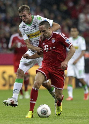 Bayern Munich's Ribery is tackled by Borussia Moenchengladbach's Kramer during German first division Bundesliga soccer match in Munich