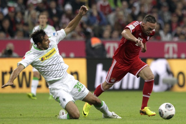Bayern Munich's Ribery is tackled by Borussia Moenchengladbach's Stranzl during German first division Bundesliga soccer match in Munich