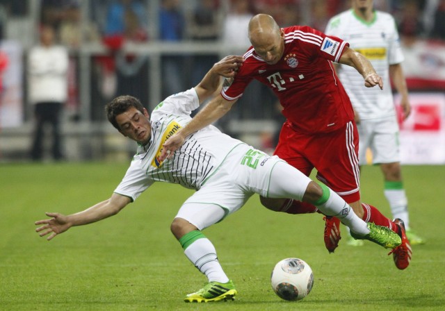 Bayern Munich's Robben is tackled by Borussia Moenchengladbach's Younes during German first division Bundesliga soccer match in Munich