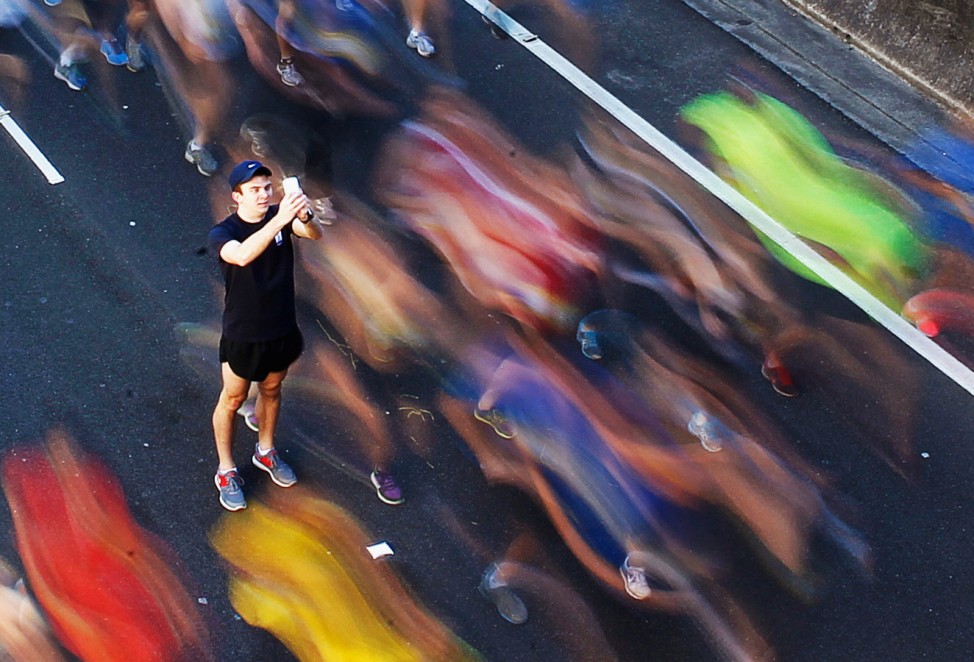 A man takes picture of himself among participants during annual 'City2Surf' fun run in central Sydney