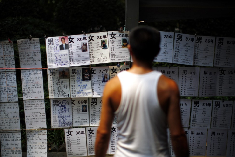A man reads signs showing the personal profiles of people looking for spouses in People's Square in downtown Shanghai