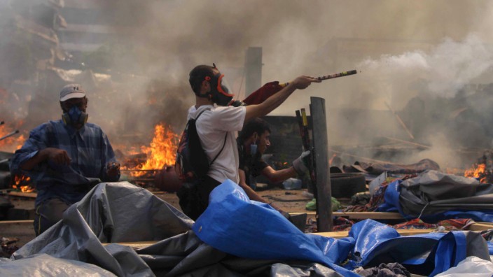 Eskalation der Gewalt in Ägypten: Gewalt in Kairo: Ein Mursi-Anhänger schießt mit Feuerwerk auf Sicherheitskräfte.
