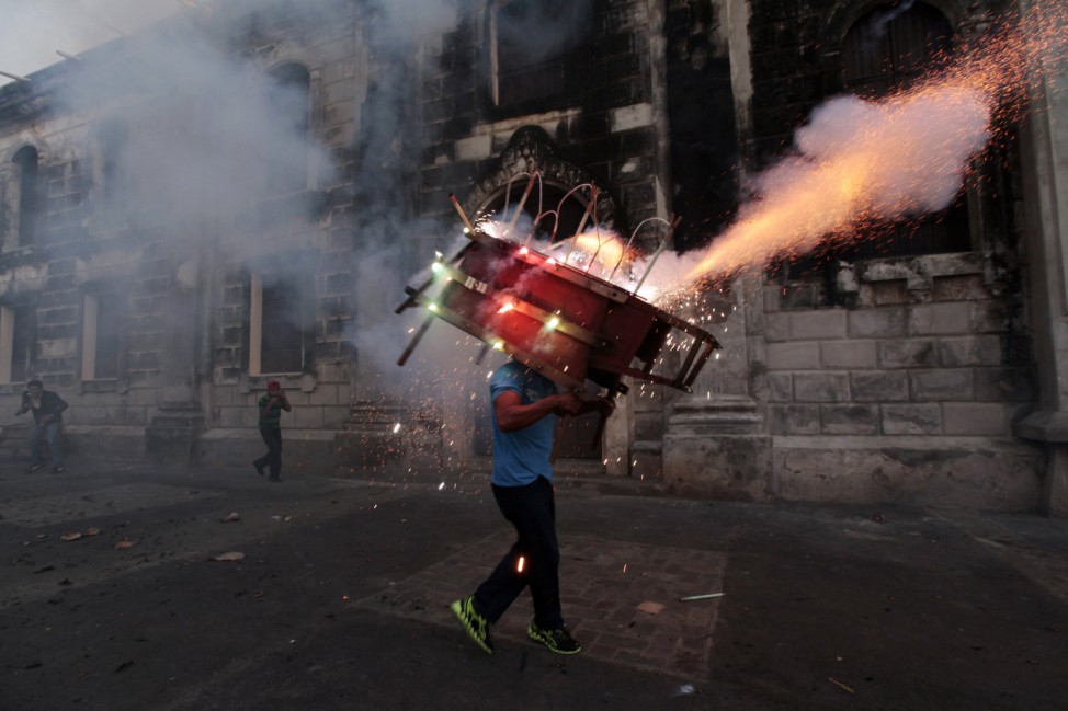 A man runs with a 'toro encuetado' during a celebration in honour of the Virgin Mary in Leon