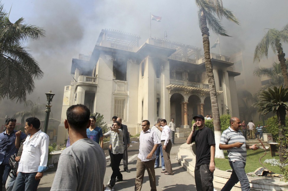 People gather outside a government building after it was set ablaze in Giza's district of Cairo
