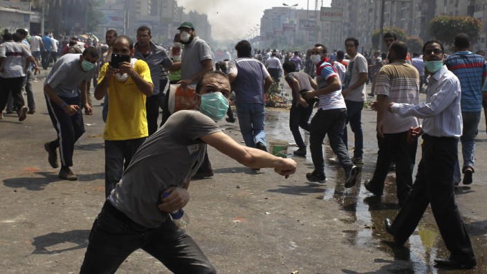 Members of the Muslim Brotherhood and supporters of ousted Egyptian President Mohamed Mursi throw stones at riot police and army personnel during clashes in Cairo