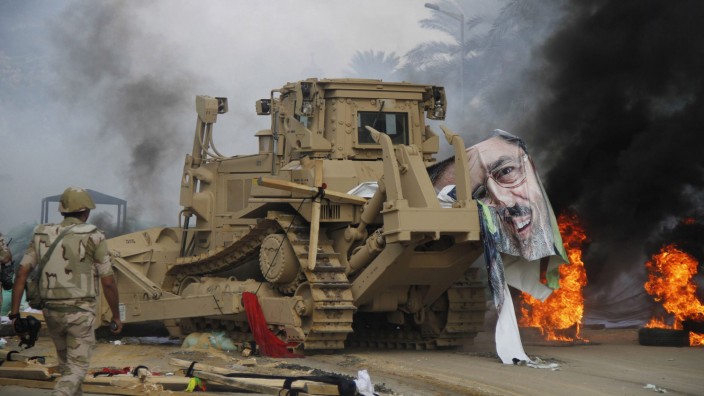 A poster of deposed Egyptian President Mohamed Mursi lies on a bulldozer near Cairo University and Nahdet Misr Square in Giza, south of Cairo