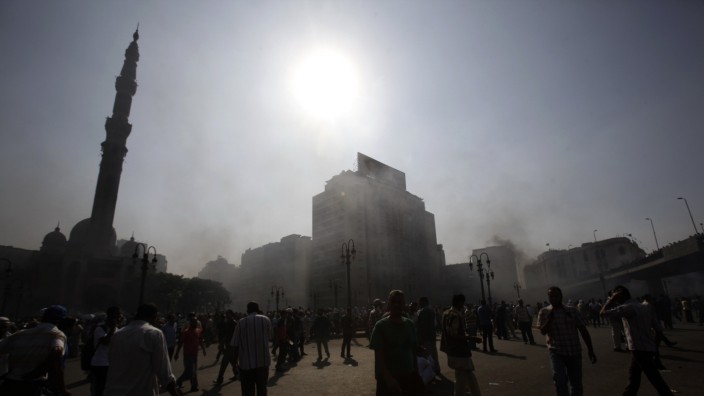 Smoke rises over Ramses Square as members of the Muslim Brotherhood and supporters of ousted Egyptian President Mohamed Mursi protest in front of Azbkya police station in Cairo