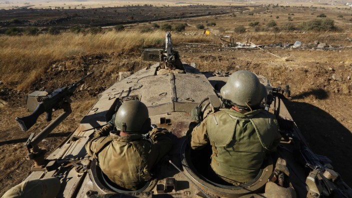 Israeli soldiers watch the border with Syria on the Israeli-occupied Golan Heights