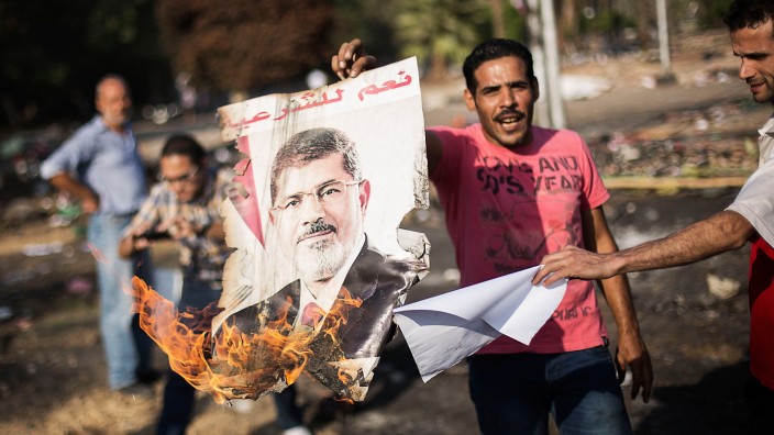 Machtkampf in Ägypten: Ägypter setzen in Kairo ein Plakat mit dem Konterfei des abgesetzten Präsidenten Mursi in Brand