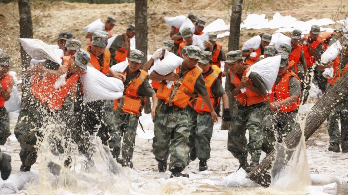 Soldiers rush to set up sand bags to prevent flood from an overflowing river in Heihe