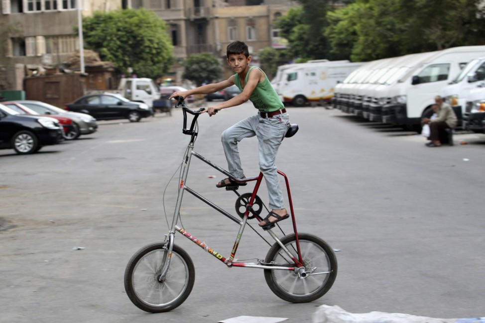 A Syrian boy living in Egypt rides his bicycle on a street in Cairo
