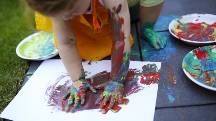 Two year-old Kaethe plays with paints in the garden of her home in Hanau