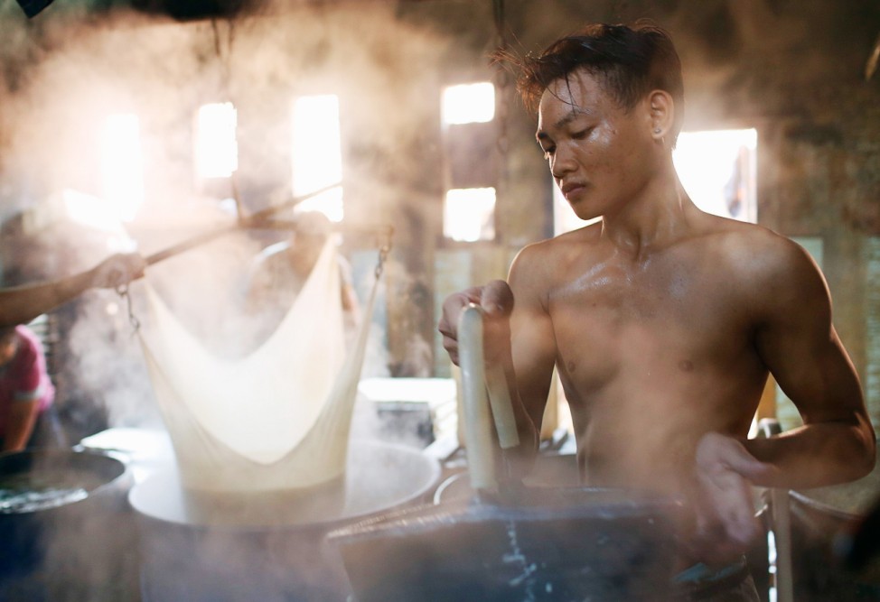 A worker cooks soybeans at a tofu factory in Jakarta