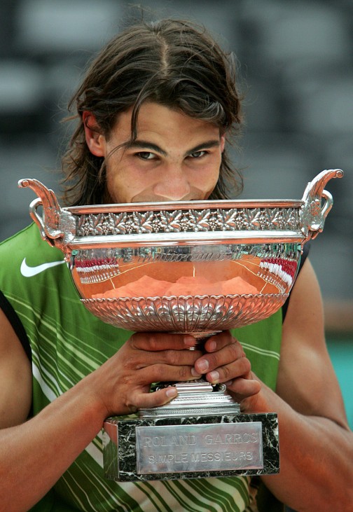 Spain's Nadal bites the winner's cup on the podium after winning his men's final against Argentina's Puerta in the French Open in Paris