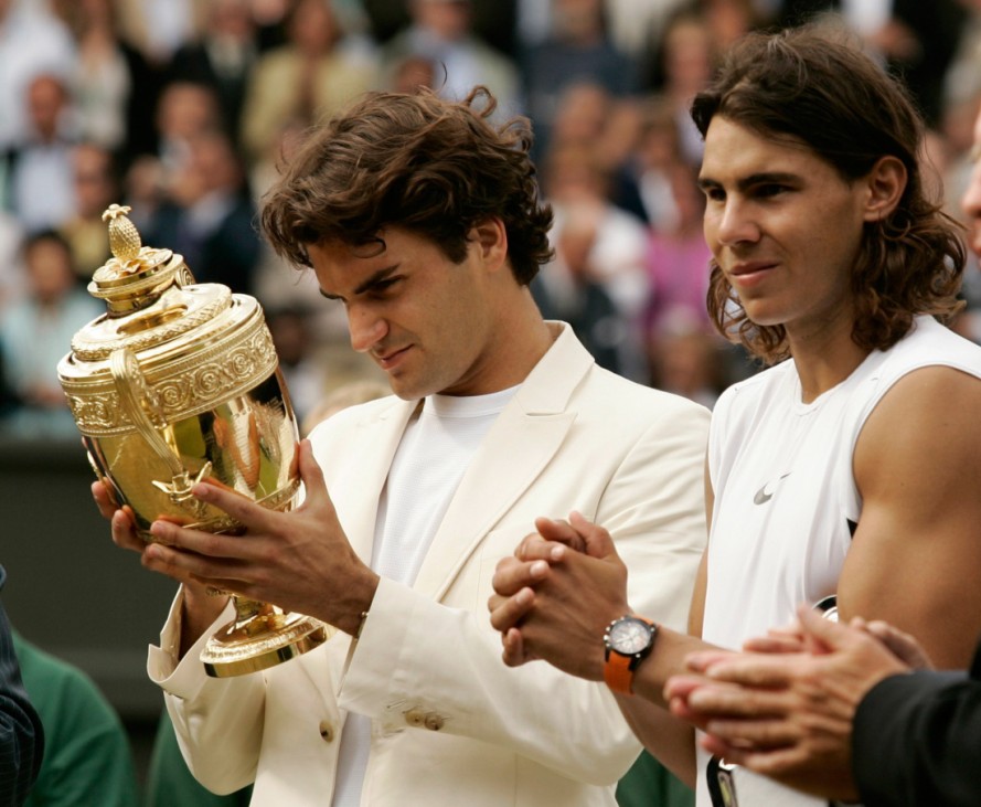 Switzerland's Federer inspects the trophy after winning his men's final match against Spain's Nadal at the Wimbledon tennis championships in London