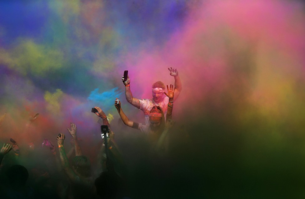 People dance among coloured powder at the finish of the Colour Run at Centennial Park in Sydney