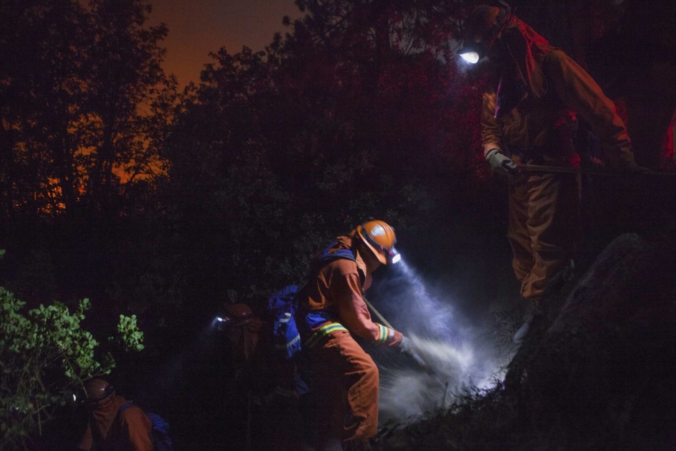 The McCain inmate crew out of San Diego cuts a fire line on a steep slope on the Rim Fire near Buck Meadows, California