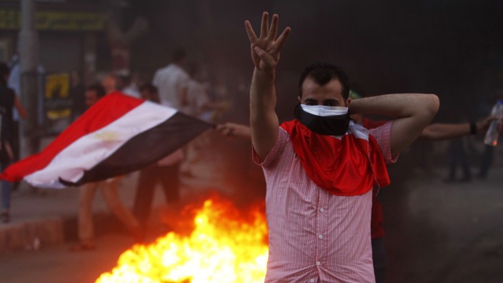 A supporter of Mursi makes the 'Rabaa' or 'Four' gesture during clashes at Mohandiseen in Cairo