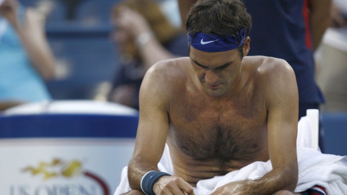 Federer of Switzerland changes his shirt during a second set break against Robredo of Spain at the U.S. Open tennis championships in New York