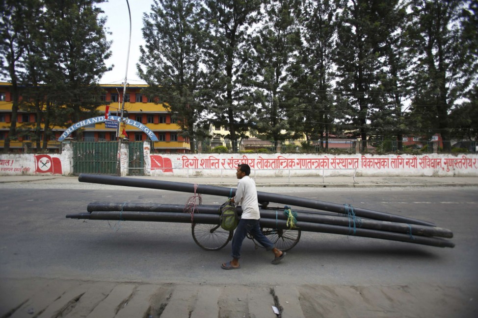 A man transports pipes on his bicycle during a general strike in Kathmandu