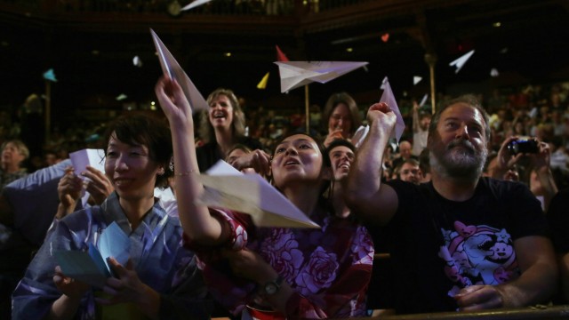 Das Publikum beteiligt sich an der Eröffnung der Zeremonie - indem es Papierflieger auf die Bühne wirft