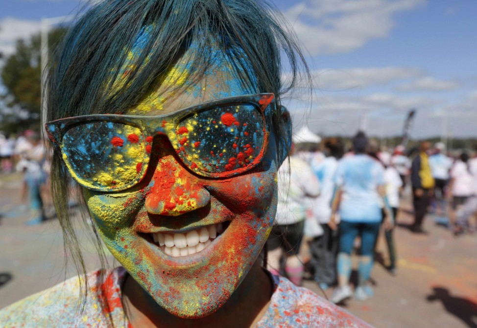 Rachel Kim of Virginia celebrates at the finish line after completing the Color In Motion 5k run with more than 12,000 other runners in Washington