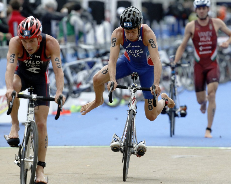 France's David Hauss jumps onto his bicycle during the transition from swimming to the cycling leg of the men's race in the ITU World Triathlon Series, at Hyde Park in London