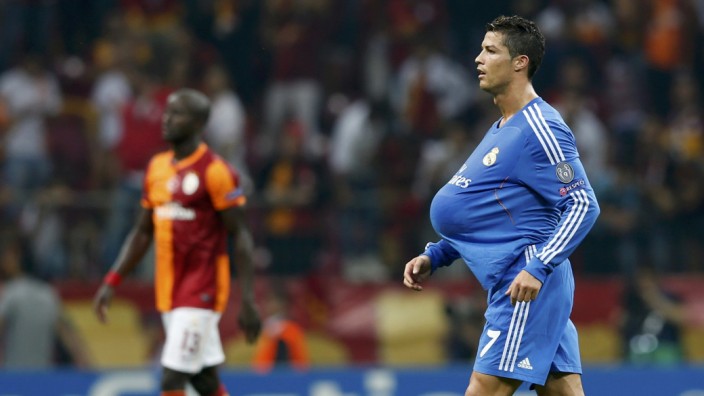 Real Madrid's Ronaldo walks on the pitch with the ball under his jersey after their Champions League soccer match against Galatasaray in Istanbul