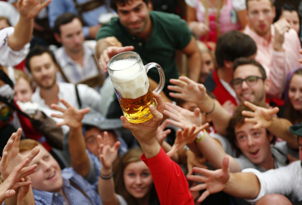 Visitors reach for the first mug of beer during opening ceremony for 180th Oktoberfest in Munich