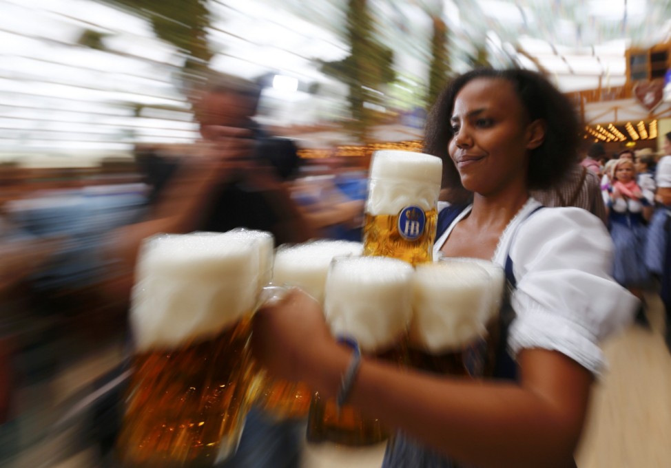 A waitress carries mugs of beer during opening ceremony for 180th Oktoberfest in Munich