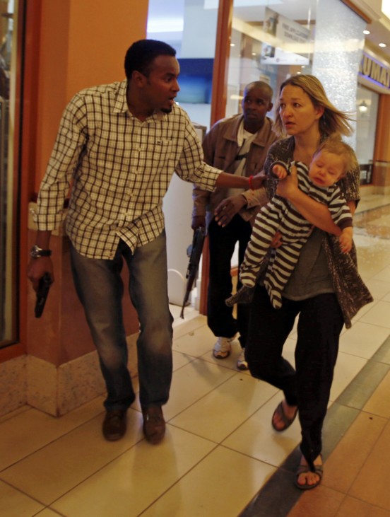 Armed police guide a woman carrying a child to safety at Westgate Shopping Centre in Nairobi