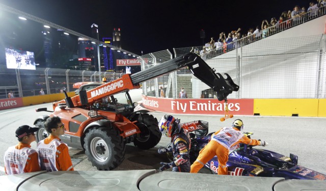 Toro Rosso Formula One driver Ricciardo walks away from his crashed car as it is recovered during the Singapore F1 Grand Prix in Singapore