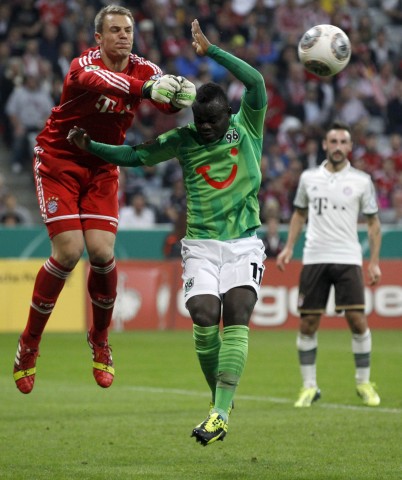 Bayern Munich's goalkeeper Neuer saves ball against Konan of Hanover 96 during German soccer cup match in Munich