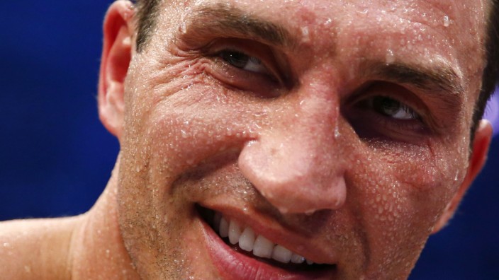 Heavyweight boxing world champion Klitschko smiles as he is covered in perspiration after defeating Pianeta in Mannheim