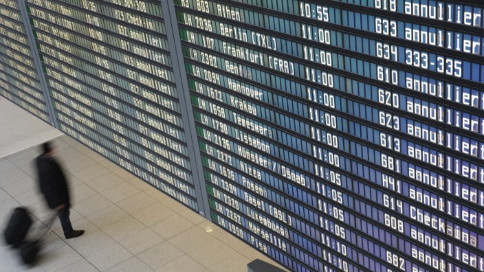 Passagier unter der Anzeigetafel auf dem Franz-Josef-Strauss Airport in München