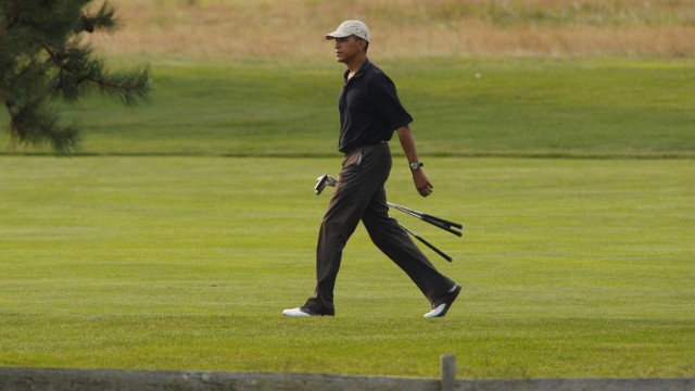 U.S. President Barack Obama walks up a fairway on the back nine during a round of golf at the Farm Neck golf course in Oak Bluffs