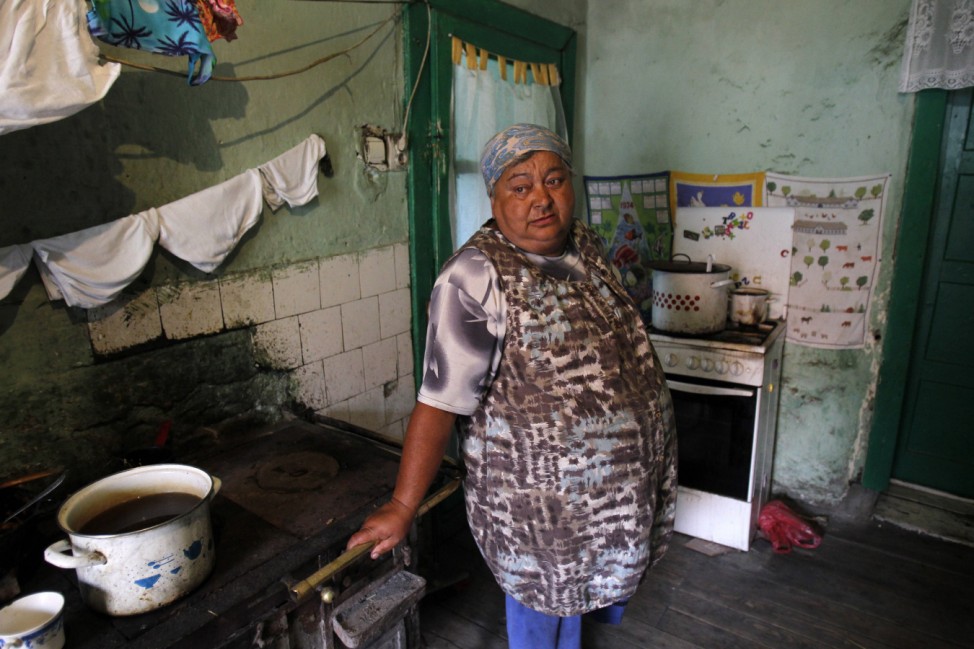Pensioner Maria Draguta poses for a photograph in her house in Aninoasa, west of Bucharest