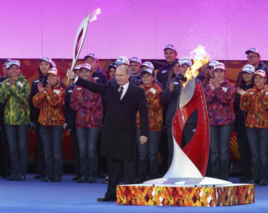 Russlands Präsident Wladimir Putin hält zum Auftakt des Fackellaufs in Moskau das Olympische Feuer in seinen Händen.