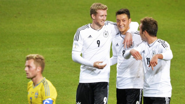 Germany's Schuerrle celebrates his goal against Sweden with teammates Ozil and Goetze behind Sweden's Larsson during their 2014 World Cup qualifying soccer match in Stockholm