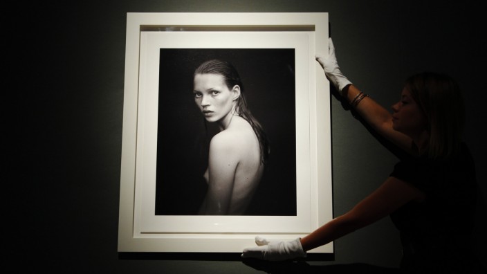 A worker poses with 'Kate Moss, for Calvin Klein Obsession campaign 1993' by photographer Mario Sorrenti, at Christie's auction house in London