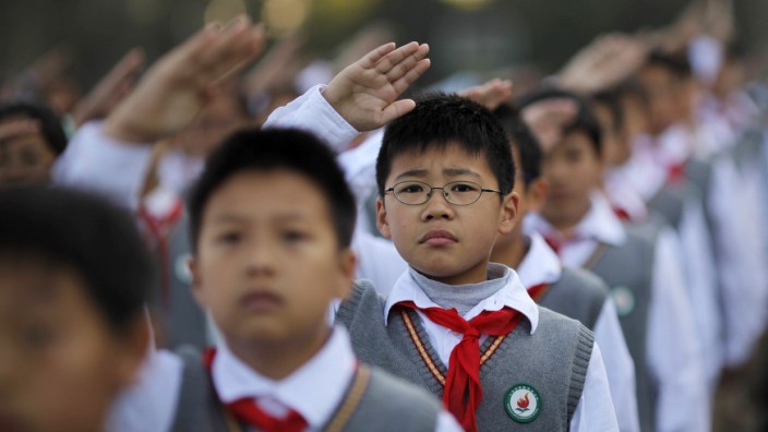 Young Pioneers salute during the weekly flag-raising ceremony at the East Experimental School in Shanghai