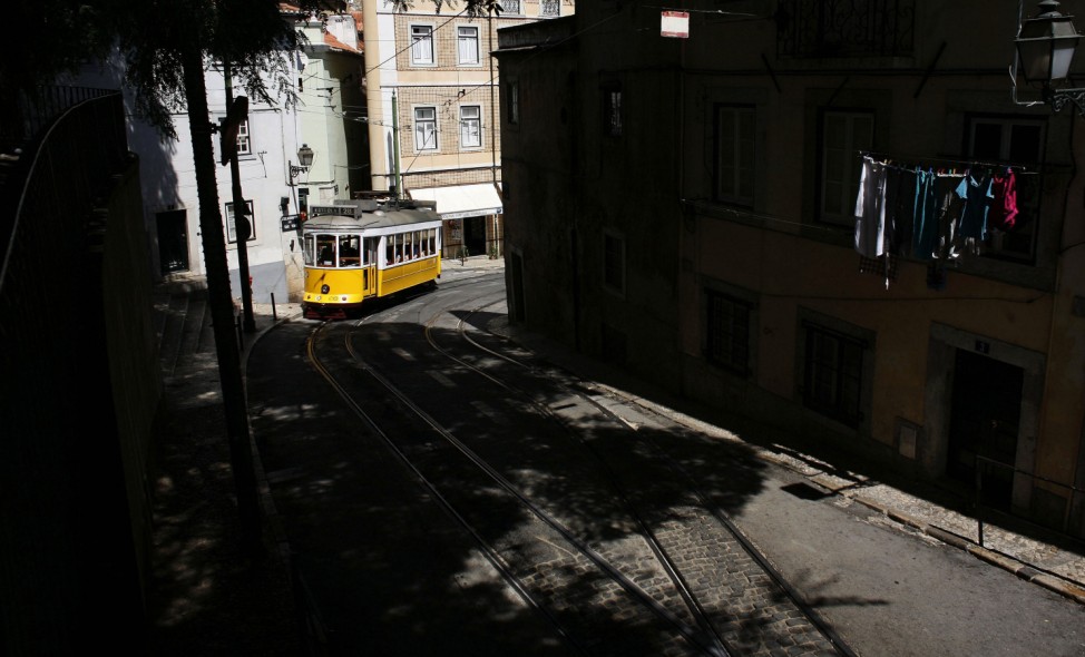 The tram 28 moves through an old neighborhood in Lisbon