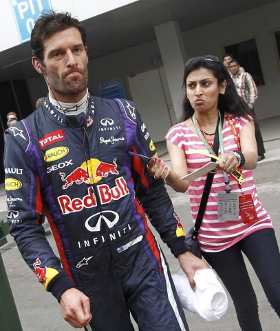 A fan asks Red Bull Formula One driver Webber for an autograph as Webber walks to his team garage after retiring from the race during the Indian F1 Grand Prix at the Buddh International Circuit in Greater Noida