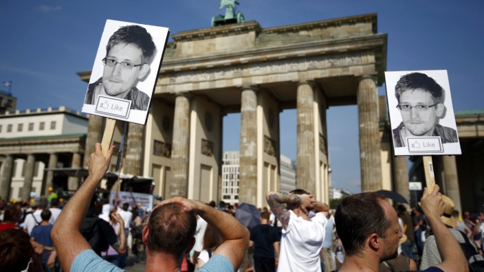 Protesters carry portraits of Snowden during a demonstration against secret monitoring programmes PRISM, TEMPORA, INDECT and showing solidarity with whistleblowers Snowden, Manning and others in Berlin