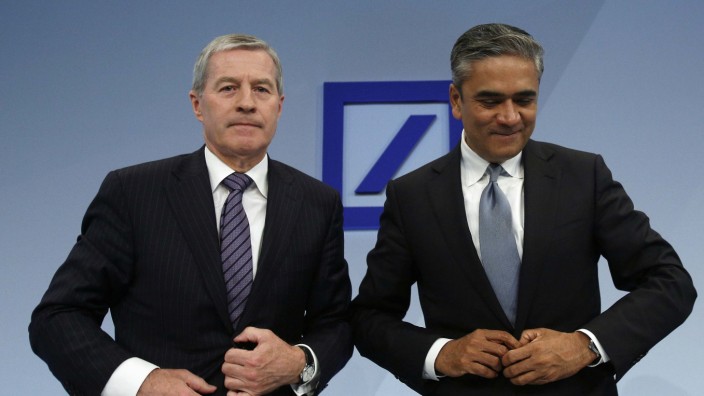Fitschen and Jain, co-chairmen of the Germany's largest business bank, Deutsche Bank AG close their jackets after the annual news conference in Frankfurt