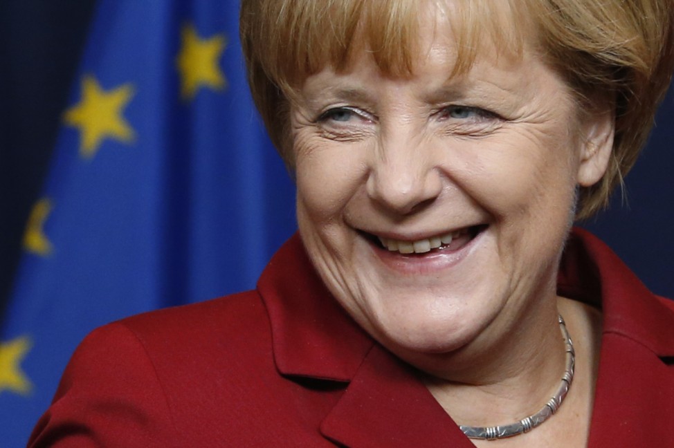 Germany's Chancellor Merkel smiles as she poses for a family photo during an European Union leaders summit in Brussels